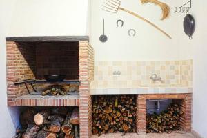 a brick oven filled with lots of logs at CASA RURAL EL TRANCO DEL LOBO in Casas de Ves