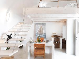 a room with a white table and a loft bed at Secret Gem Suites in Oia