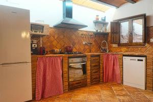 cocina con armarios de madera y horno con fogones en CASA RURAL EL TRANCO DEL LOBO, en Casas de Ves