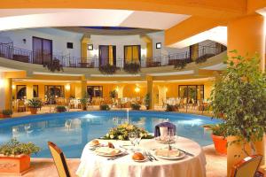 un hotel con piscina y mesa con comida en Apartments Dolcestate, Campofelice di Rocce, en Buonfornello