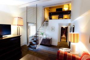 un salon avec un escalier et une télévision dans l'établissement Le Tre Vaselle Resort & Spa, à Torgiano