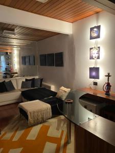 a living room with a glass table and a couch at Apartamento lindo e aconchegante em Capivari. in Campos do Jordão