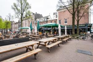 a group of picnic tables and umbrellas on a city street at Residences Rijksmuseum in Amsterdam