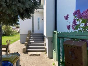 ein weißes Haus mit einer Treppe, die zu einer Tür führt in der Unterkunft Jelenec House in Jelenec