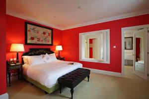 a bedroom with red walls and a bed with a stool at The Yeatman in Vila Nova de Gaia