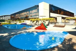2 piscinas frente a un edificio en Residence Riviera Palace Loano - ILI02225-CYC, en Loano