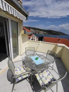 un tavolo e sedie su un balcone con vista sull'acqua di Apartments Vito a Trogir
