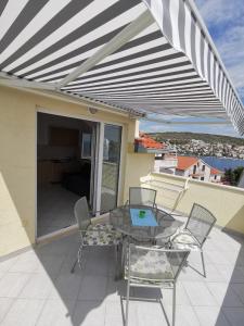 un patio con tavolo e sedie sul balcone. di Apartments Vito a Trogir