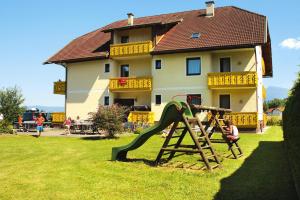 a child playing on a playground in front of a house at Apartment in St Kanzian 800 m from the lake in Srejach