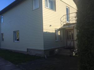 a white house with a staircase leading to the front door at Transvaali 28 B&B in Kuressaare