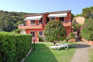 a house with a bench and a tree in the yard at Apartments Villa Franca in Capoliveri in Capoliveri