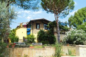 a house behind a wall with a tree at Apartment in Guardistallo with heating in Guardistallo