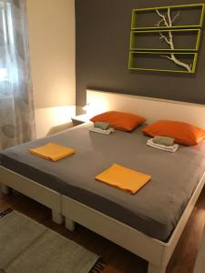 a bed with orange pillows on it in a room at Apartments Sanja in Makarska