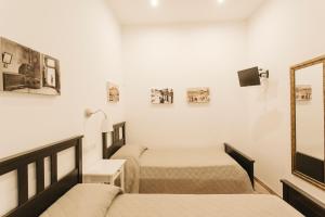 1 dormitorio con 2 camas y espejo en Giulietta nei Sassi, en Matera