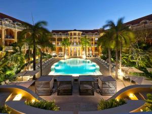 un complejo con una gran piscina con palmeras en Sofitel Legend Santa Clara Cartagena en Cartagena de Indias