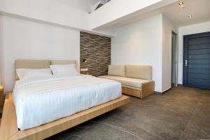a bedroom with a large bed and a chair at Epicentrum Suites in Limenaria