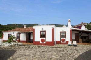 un edificio bianco e rosso con due sedie davanti di Holiday Home Puntallana - SPC02018-F a Puntallana