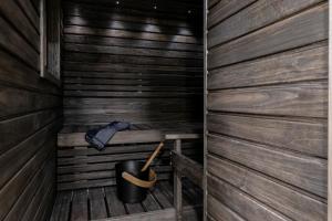 a wooden sauna with a bucket and a hat at Lapland Hotels Arena in Tampere