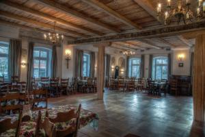a dining room with tables and chairs and windows at Karczma Bełty in Glinno