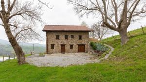 a small stone house on a hill with trees at ARBELA Apartamentuak in Aia