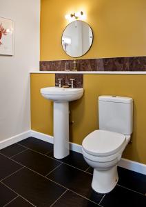 a bathroom with a white toilet and a sink at The Barrington Boar in Ilminster