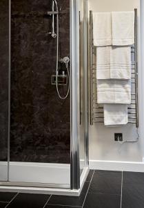 y baño con ducha y toallas blancas. en The Barrington Boar en Ilminster