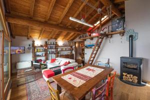 Habitación con mesa y estufa de leña. en Baita di charme con vista meravigliosa en Verrayes