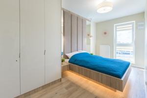 1 dormitorio con 1 cama con manta azul en HollyŁódź Apartment NETFLIX, en Łódź