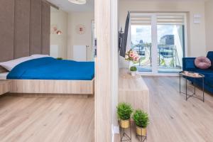 sypialnia z niebieskim łóżkiem i balkonem w obiekcie HollyŁódź Apartment NETFLIX w Łodzi