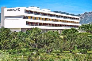 a large white building with trees in front of it at Golden Tulip Porto-Vecchio in Porto-Vecchio