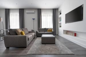a living room with two couches and a flat screen tv at Harmony Luxury Rooms in Castellammare di Stabia