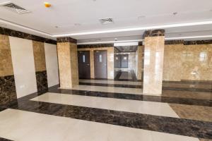 a lobby with black and white floors and columns at Budget Rental Apartments in Dubai in Dubai