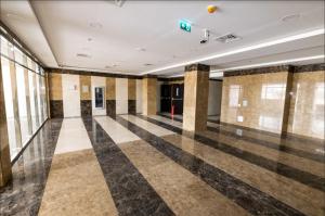 um quarto amplo com piso em xadrez e janelas em Budget Rental Apartments in Dubai em Dubai