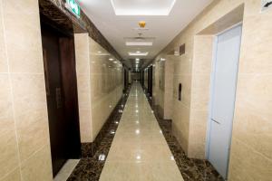 a long hallway in a building with tile walls at Budget Rental Apartments in Dubai in Dubai