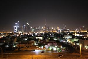 uma cidade iluminada à noite com o horizonte da cidade em Budget Rental Apartments in Dubai em Dubai