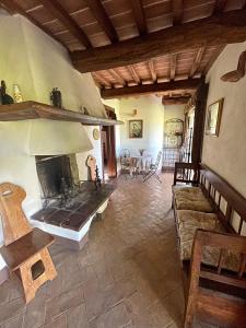 a living room with a fireplace and a table at Fonte del Salcio in Cinigiano