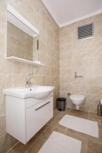 Armoni Deluxe Suites Trabzon في طرابزون: حمام مع حوض أبيض ومرحاض