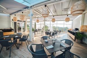 restauracja ze stołami, krzesłami i oknami w obiekcie Molo Park Aparthotel w mieście Mielno +37 zdjęć