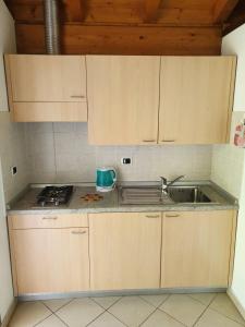 a kitchen with wooden cabinets and a sink at Bungalows in Camping Solarium in Domaso
