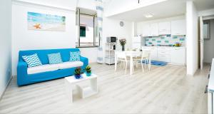 uma sala de estar com um sofá azul e uma mesa em Casa Acqua Marina em Amalfi