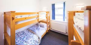 Habitación con 2 literas y ventana en White Park Bay Youth Hostel, en Ballintoy