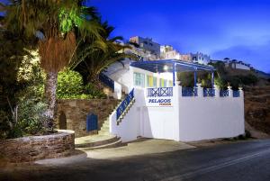 un bâtiment blanc avec un panneau sur le côté d'une rue dans l'établissement Ios Pelagos, à Ios Chora