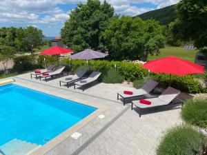 una piscina con sillas y sombrillas junto a una piscina en Villa Anne A lovely place in the mountains, en Brest