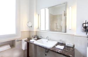 パリにあるホテル クラリッジ パリの白いバスルーム(シンク、鏡付)