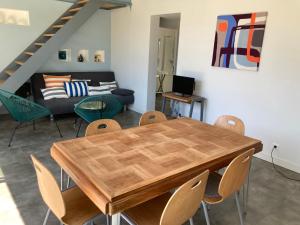 uma sala de estar com uma mesa e cadeiras de madeira em Maison contemporaine Oléron em Saint-Denis-dʼOléron mais 4 fotografias