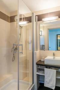 La salle de bains est pourvue d'une douche et d'un lavabo. dans l'établissement Contact Hôtel Astréa Nevers Nord et son restaurant la Nouvelle Table, à Varennes-Vauzelles