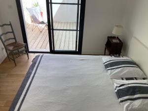 uma cama num quarto com vista para um pátio em Maison contemporaine Oléron em Saint-Denis-dʼOléron
