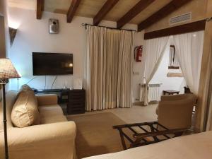 a living room with a couch and a television at Agroturisme Na Martina in Portopetro