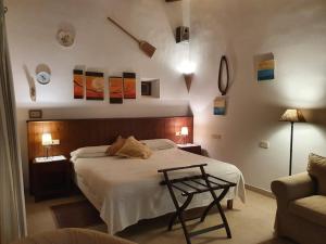 a bedroom with a bed with a table and a couch at Agroturisme Na Martina in Portopetro