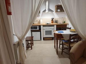 a kitchen with a table and a dining room at Agroturisme Na Martina in Portopetro